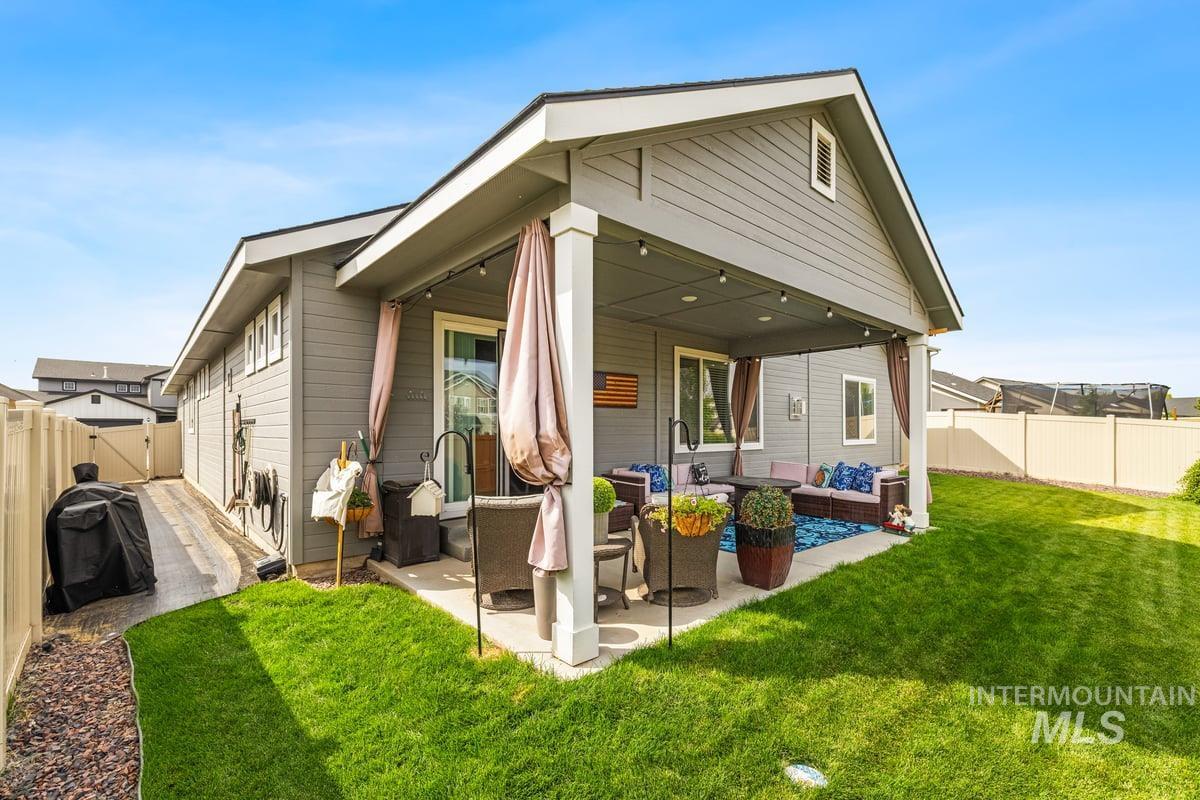 Back of property featuring an outdoor hangout area, a fenced backyard, and a patio