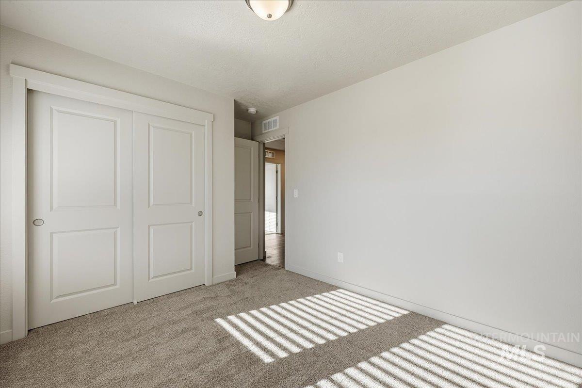 Unfurnished bedroom with a closet, carpet flooring, and a textured ceiling