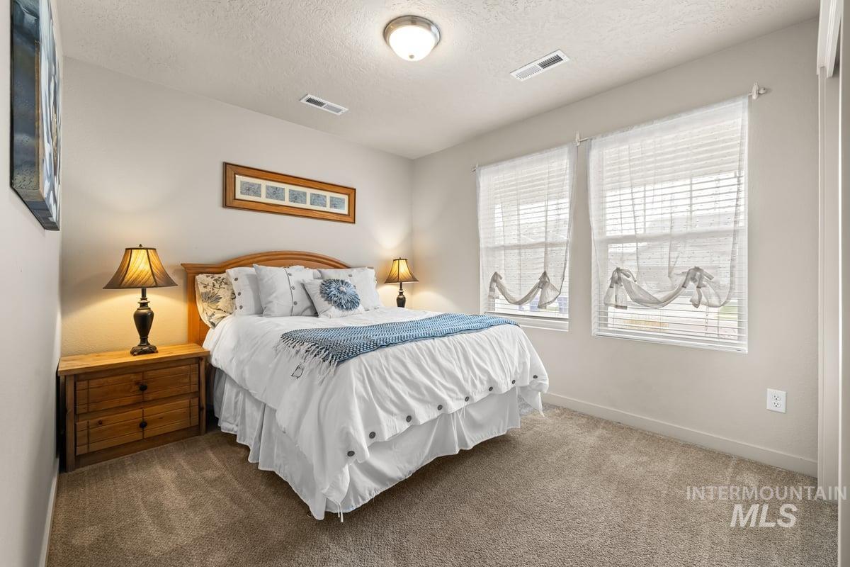 Bedroom featuring carpet floors and a textured ceiling