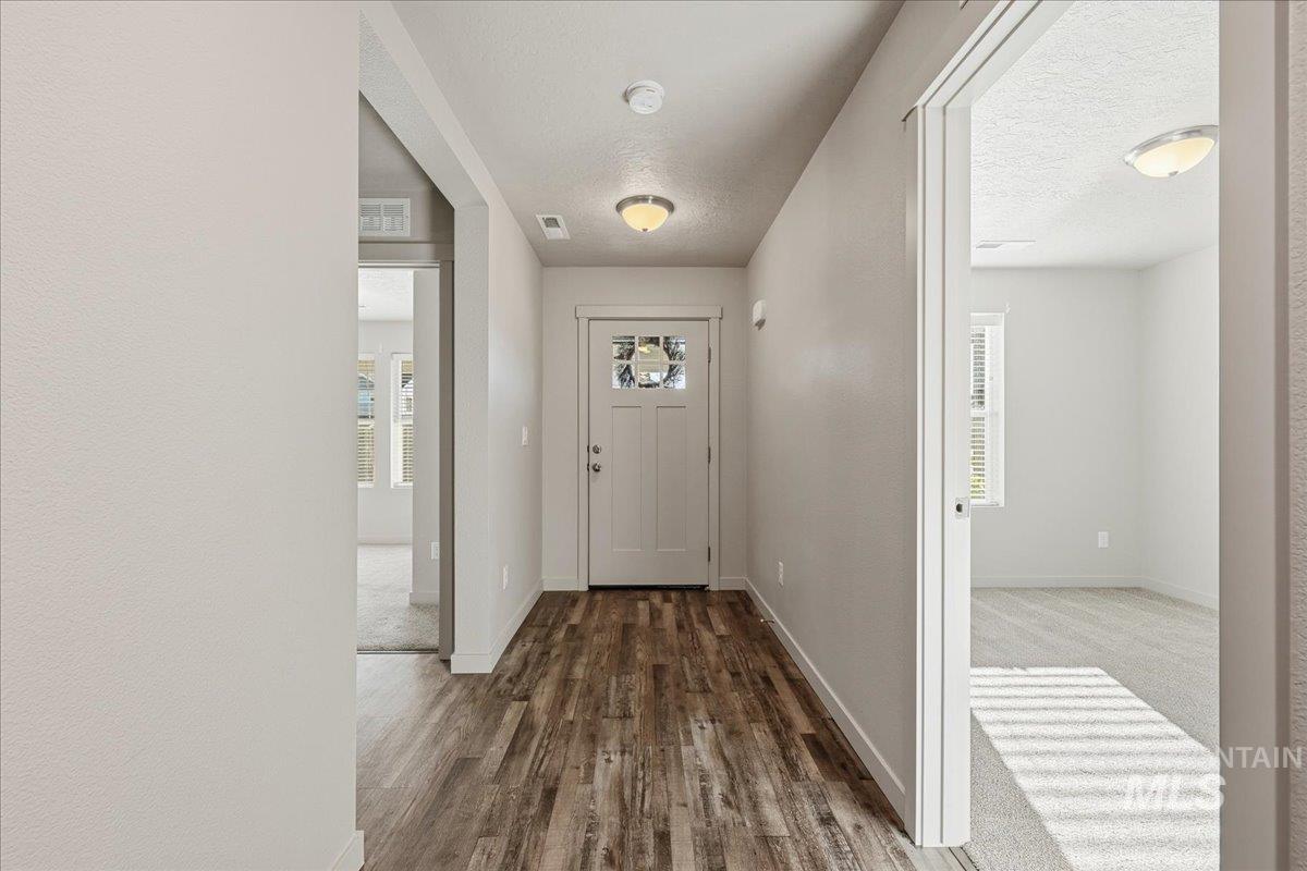 Foyer with dark wood finished floors and a textured ceiling
