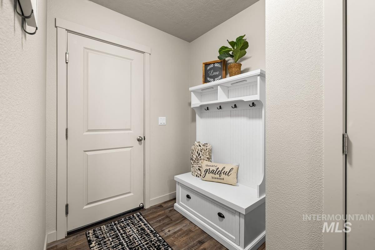 Mudroom featuring dark wood-type flooring and a textured ceiling