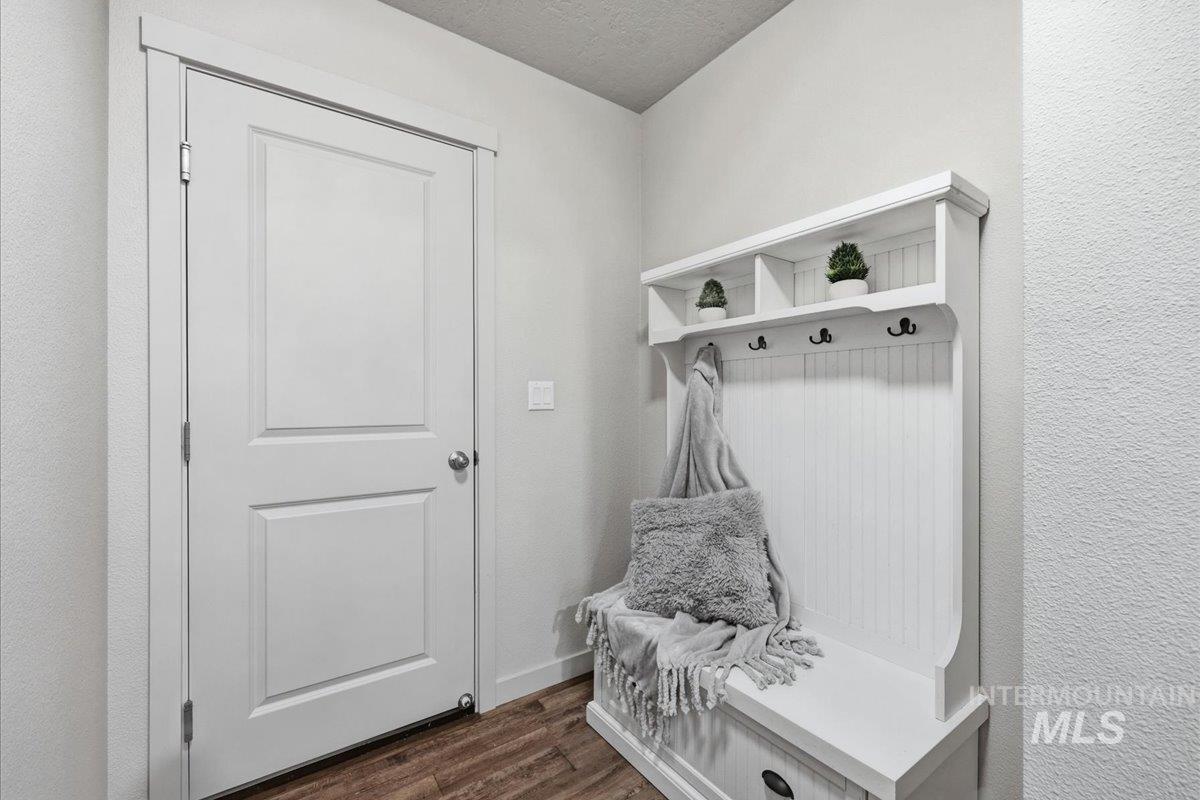 Mudroom featuring dark wood finished floors and a textured ceiling