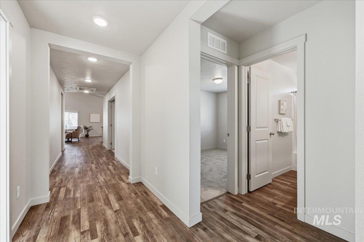 Corridor with dark wood-style flooring and a textured ceiling