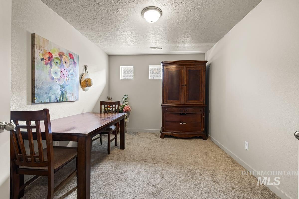 Dining room featuring light carpet and a textured ceiling