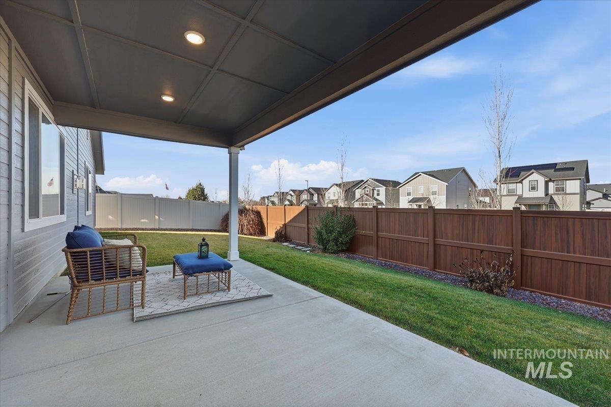 Fenced backyard featuring a patio and a residential view