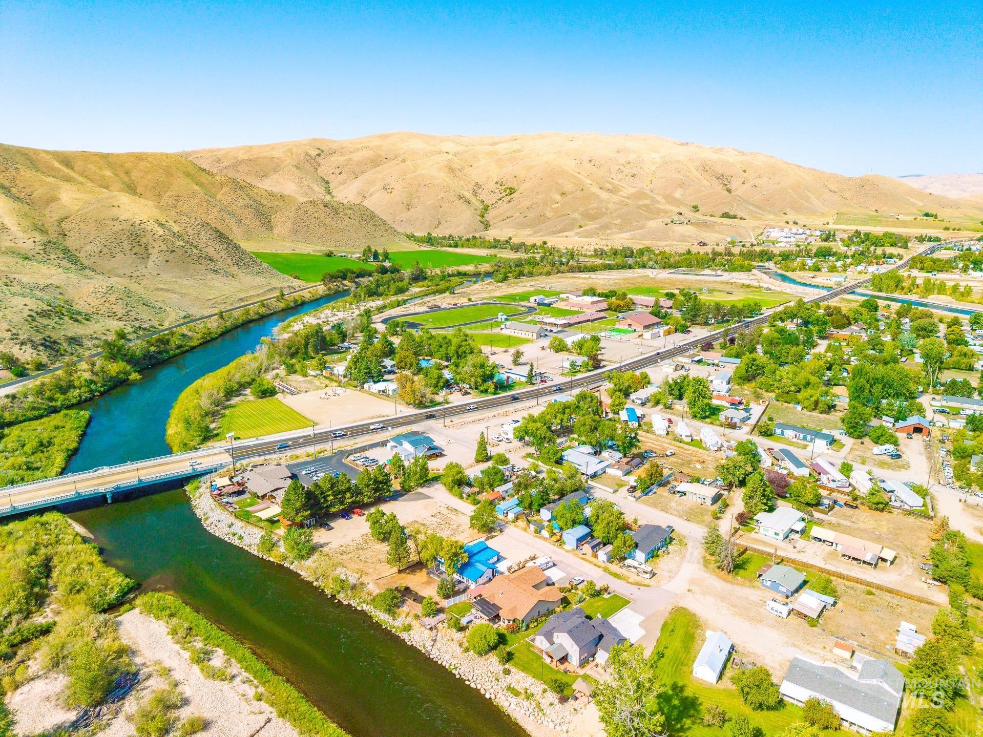 Aerial perspective of suburban area featuring a notable bridge and a water and mountain view