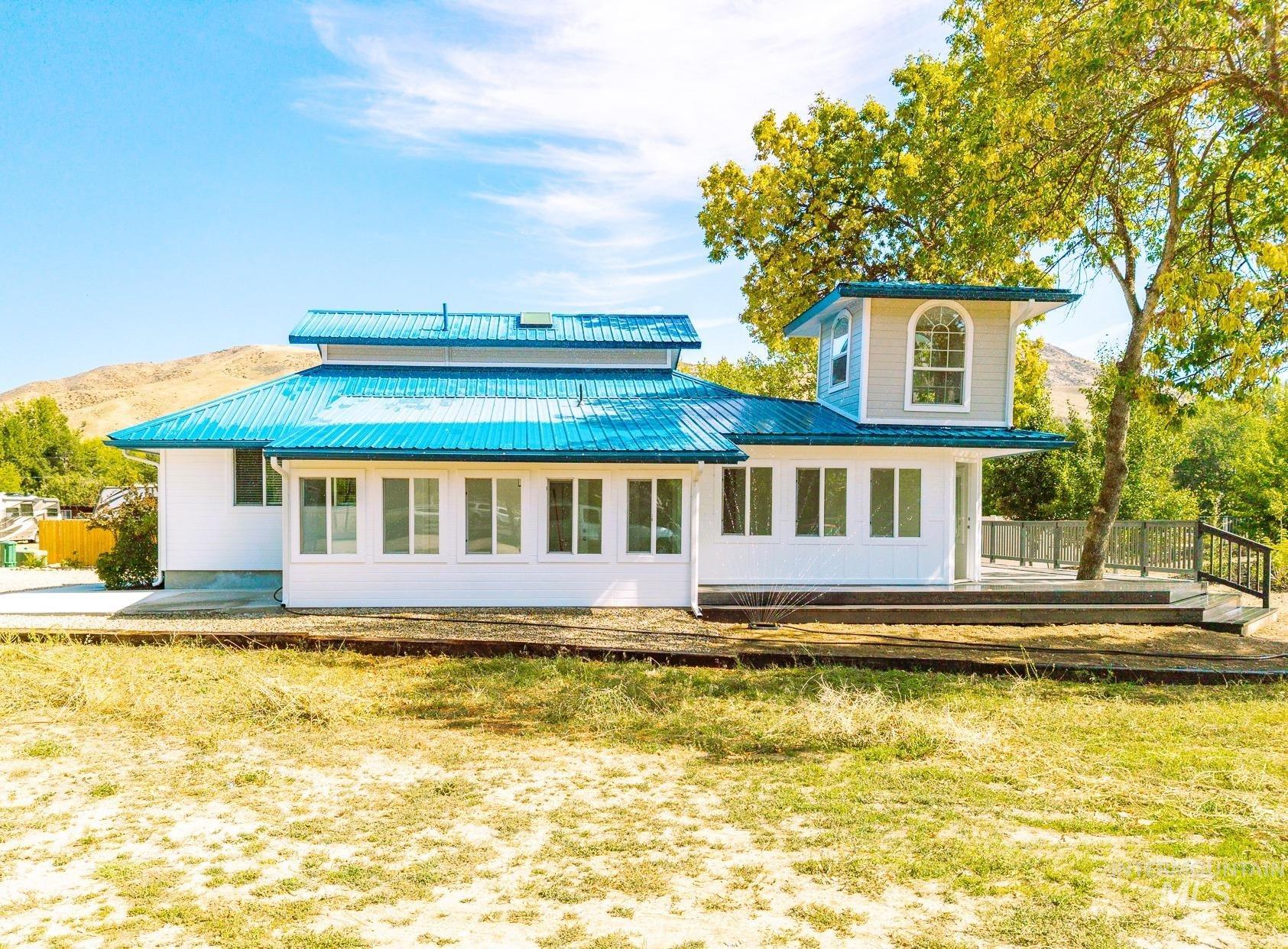 Rear view of house with a metal roof and a deck with mountain view