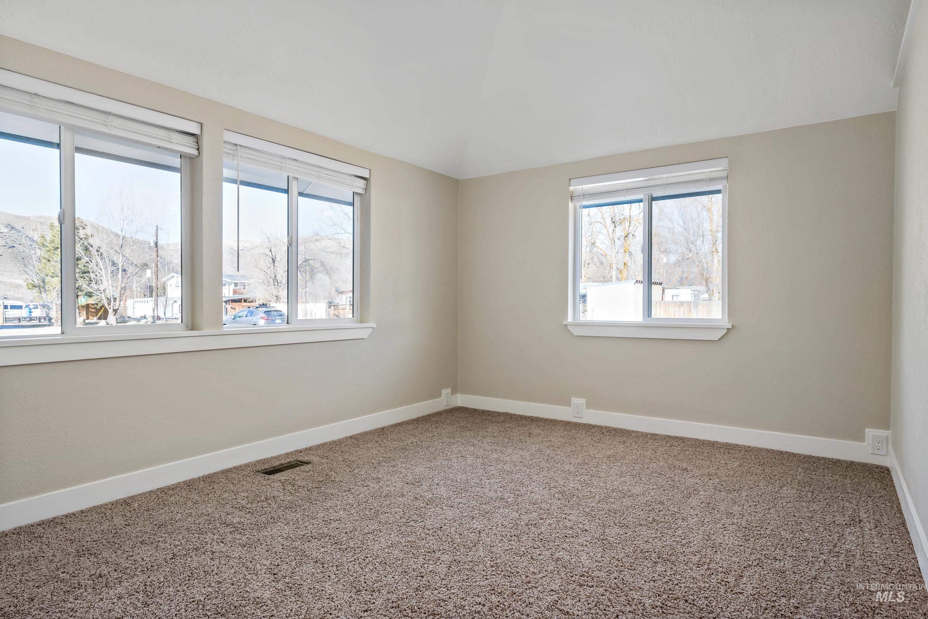 Carpeted empty room featuring baseboards