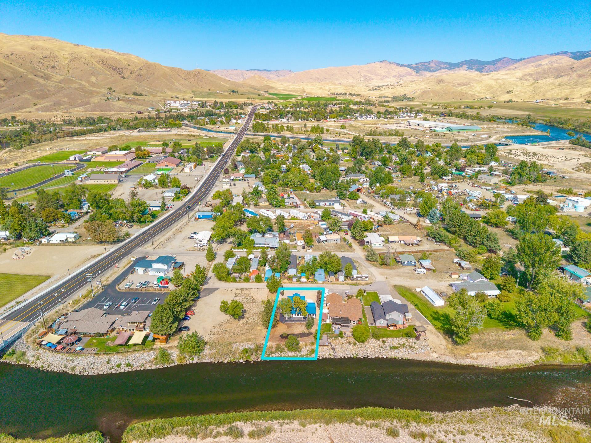 Aerial overview of property's location with property parcel outlined and a water and mountain view