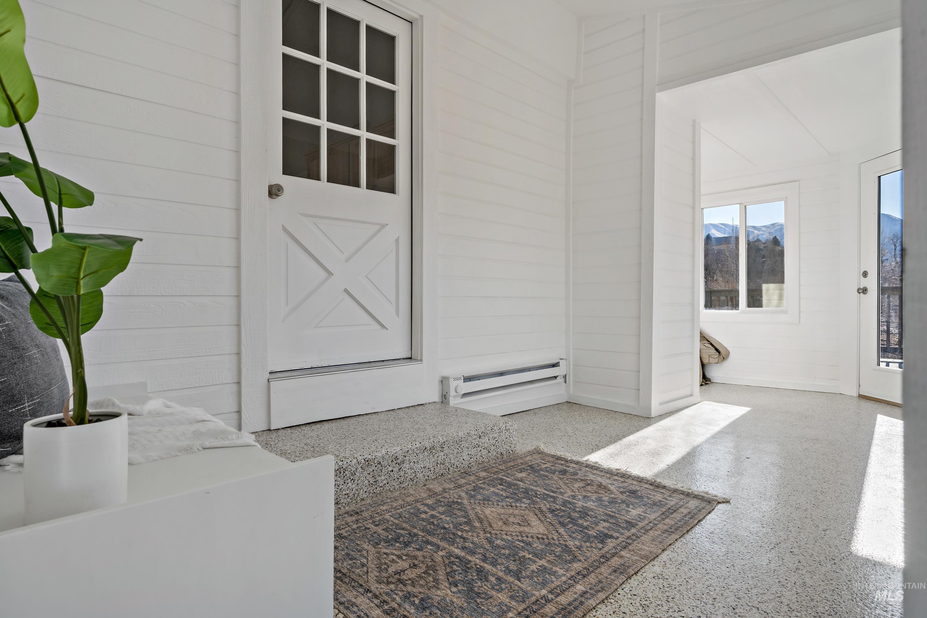 View of exterior entry with baseboard heating