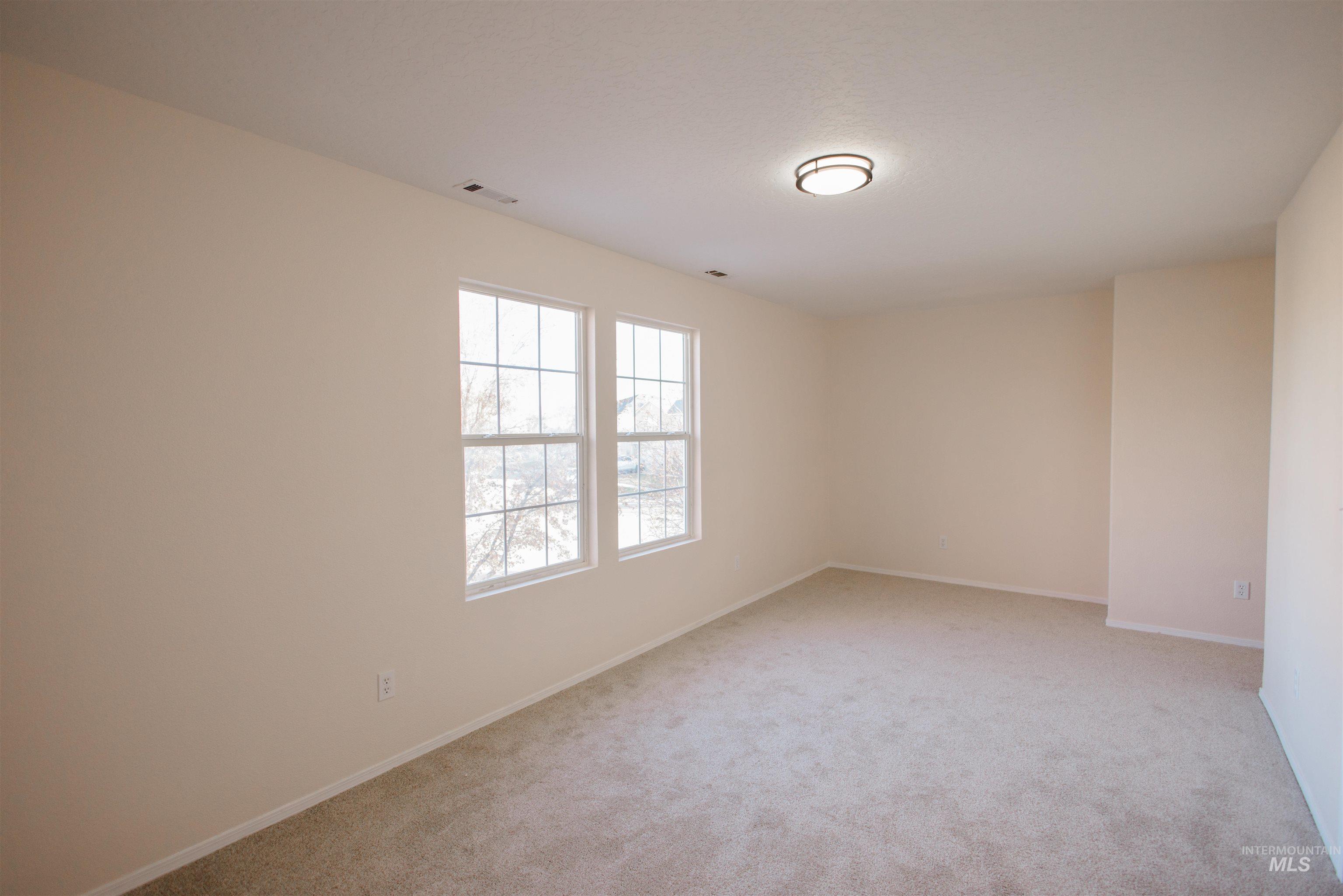 Spare room with light carpet and baseboards
