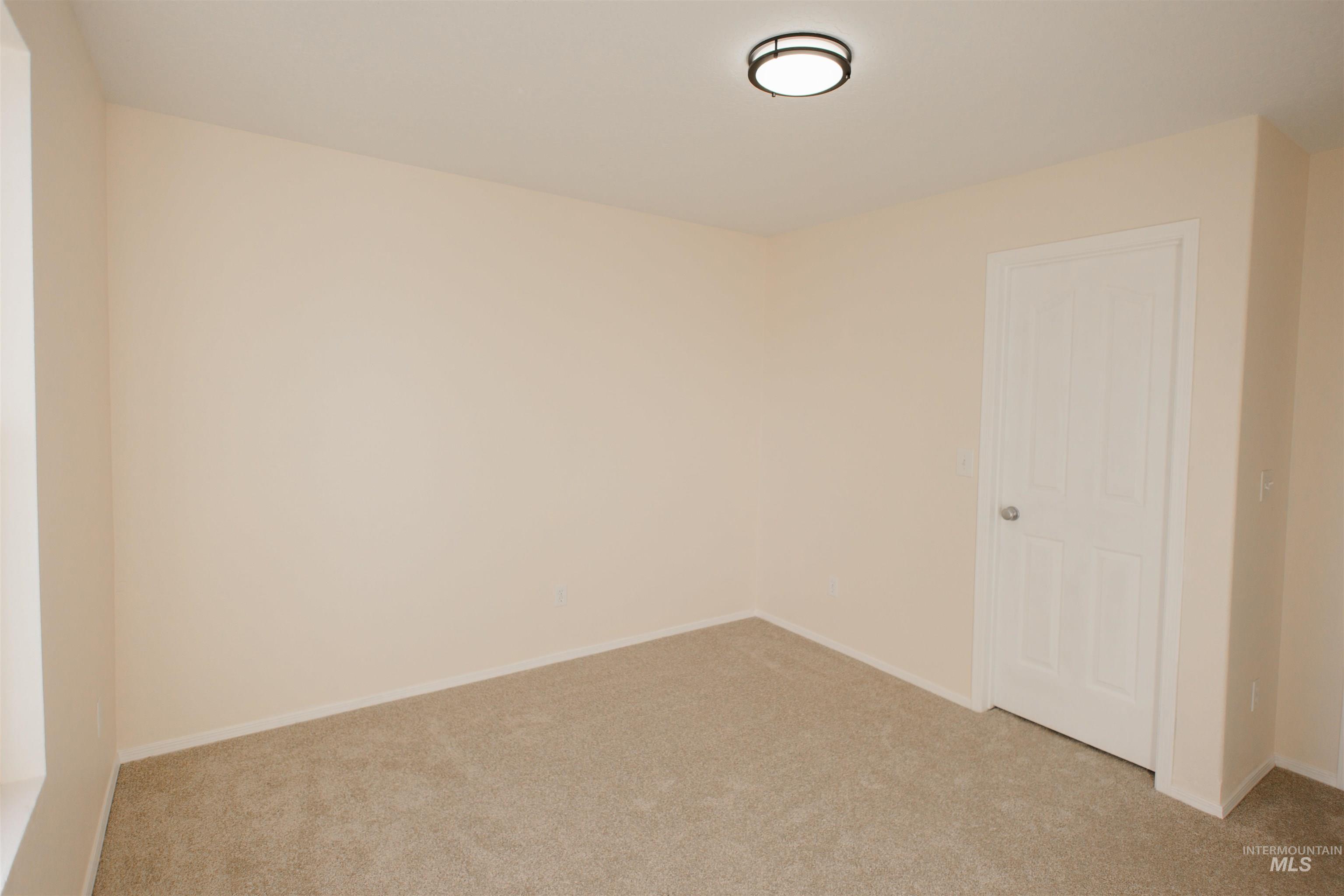 Empty room featuring light colored carpet