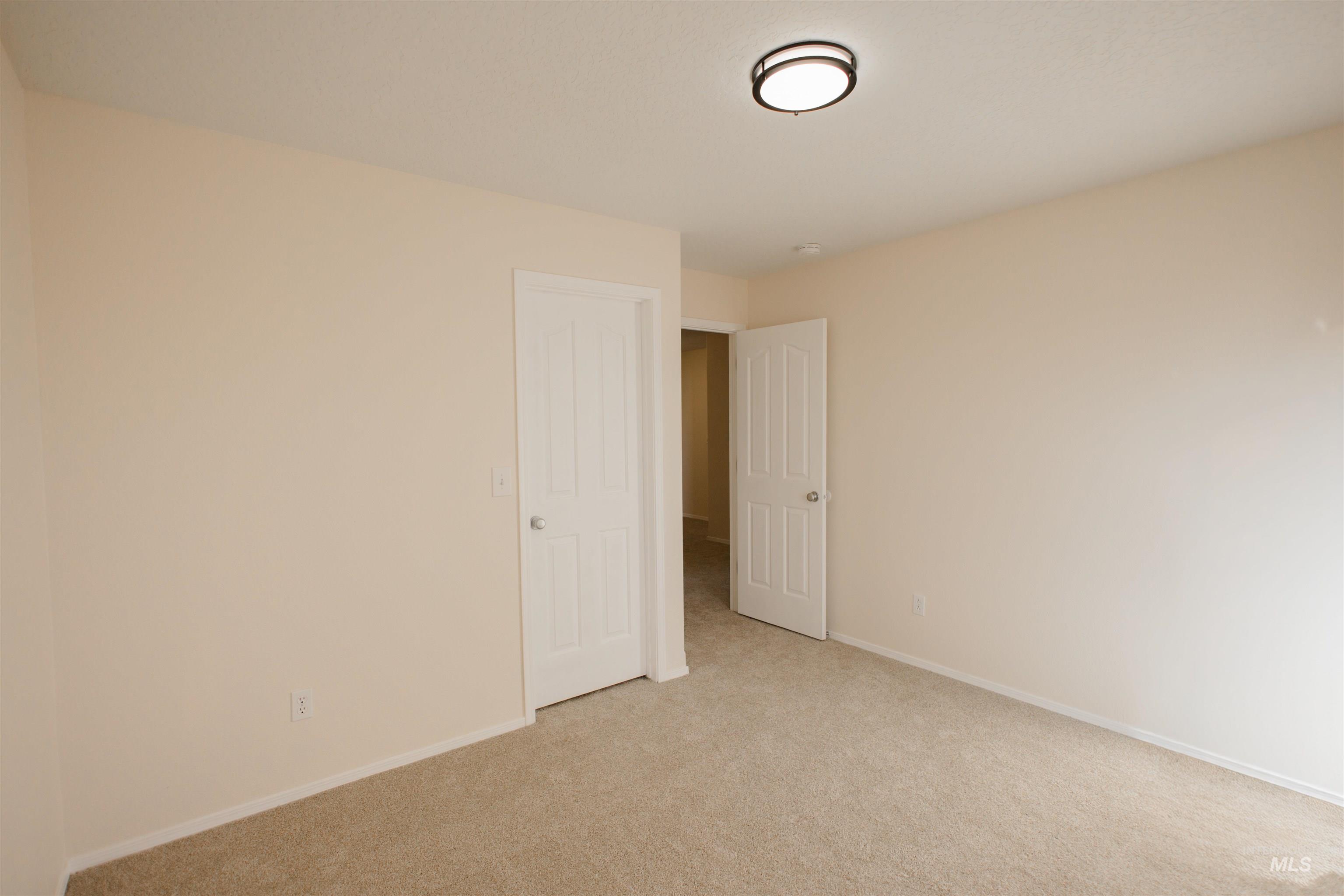 Unfurnished room featuring light colored carpet and baseboards