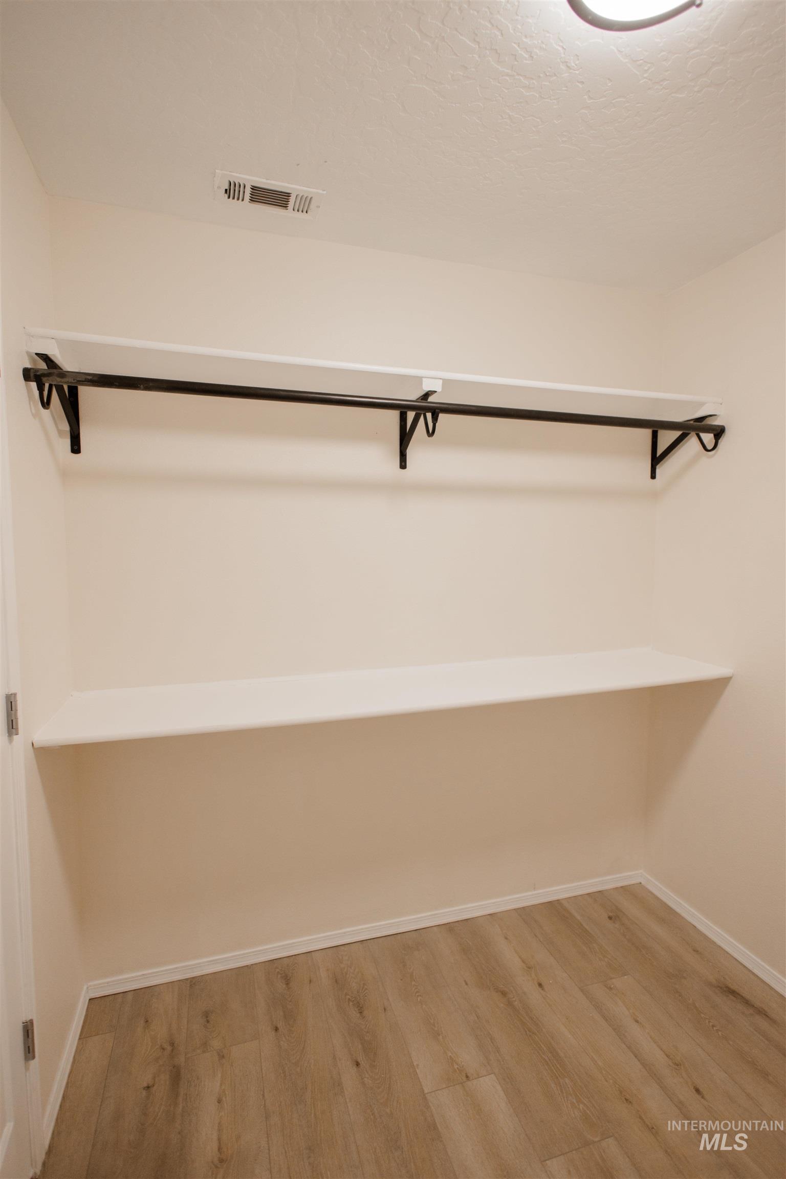 Spacious closet with light wood-style flooring