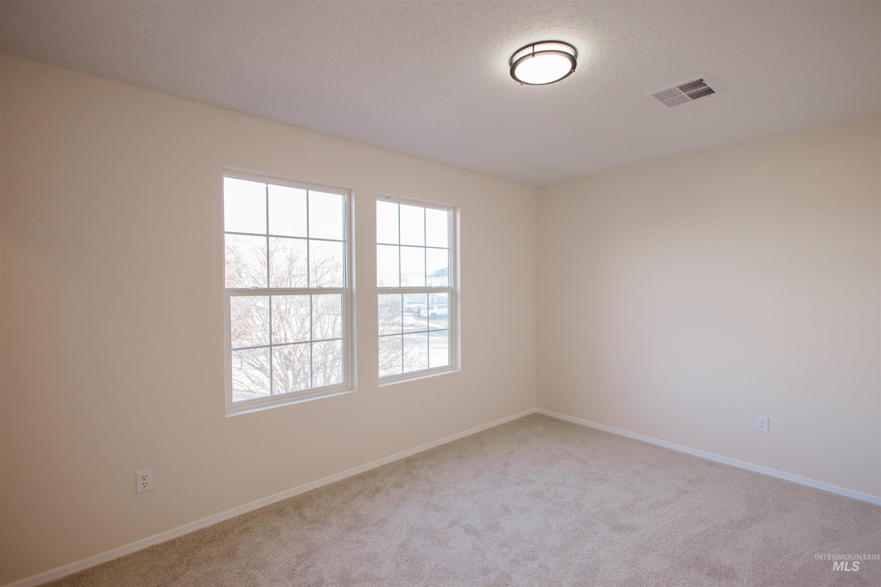 Spare room with baseboards and light carpet