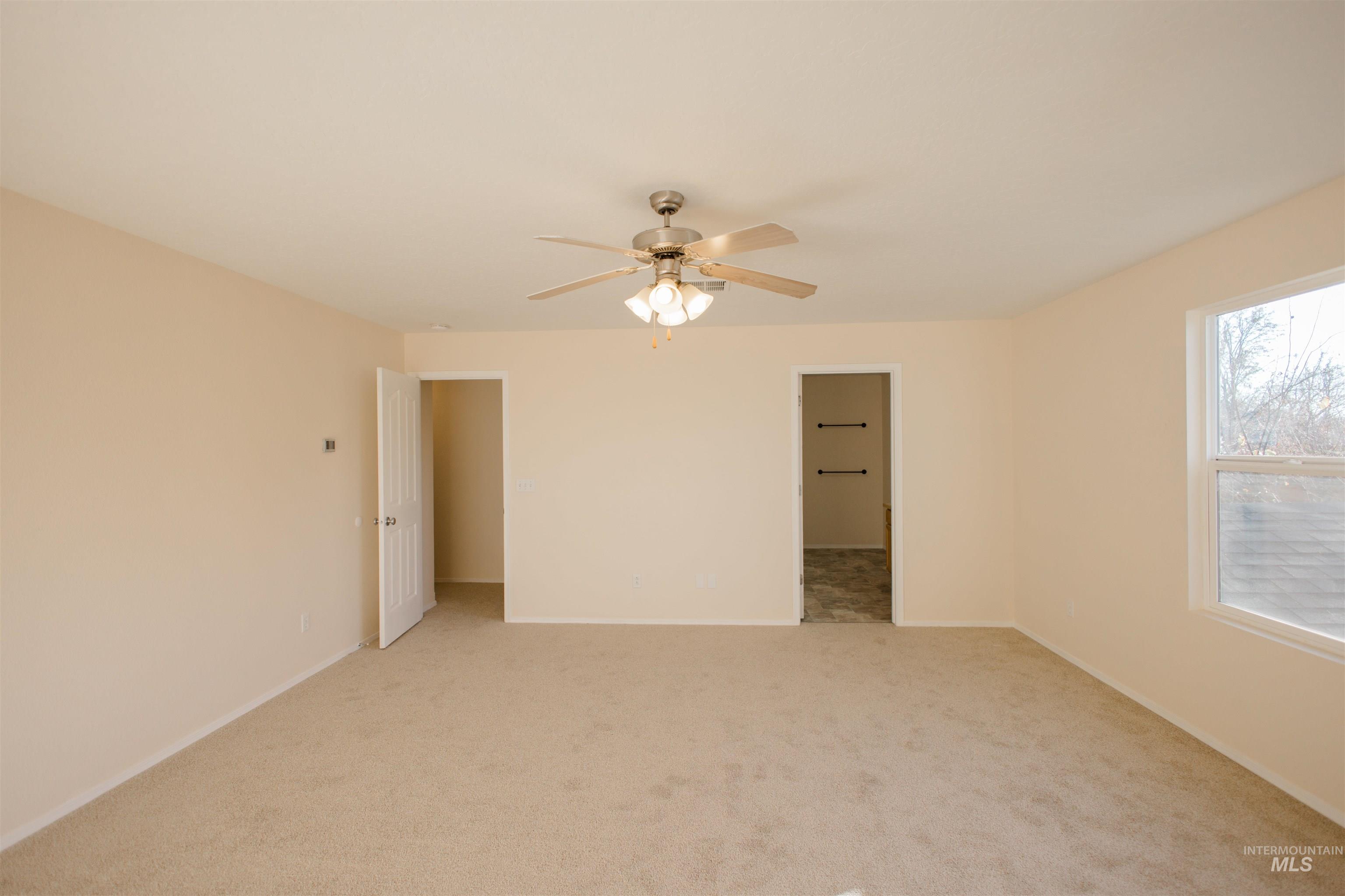 Unfurnished room with light carpet and ceiling fan