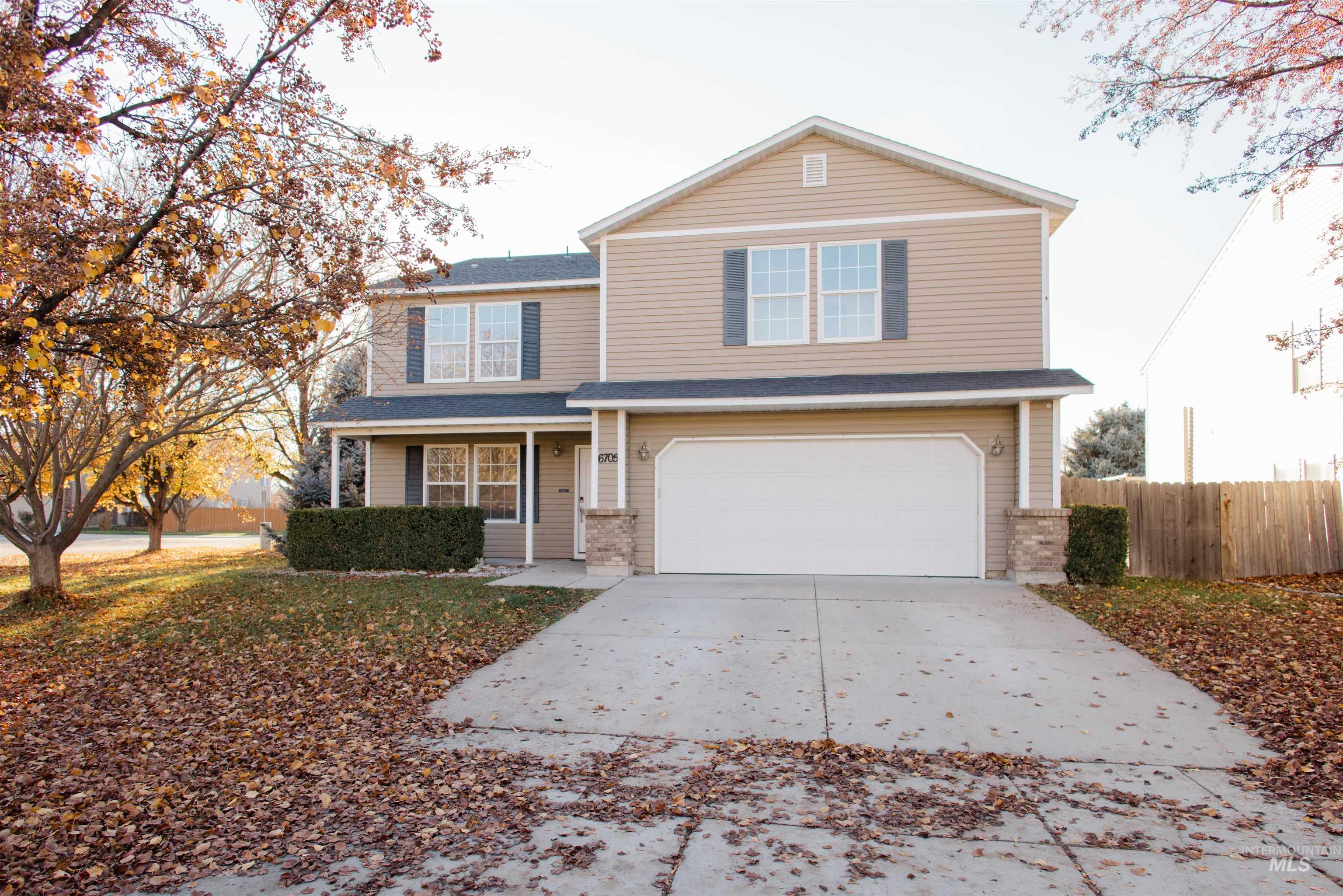 Traditional-style home with driveway, an attached garage, covered porch, and a shingled roof