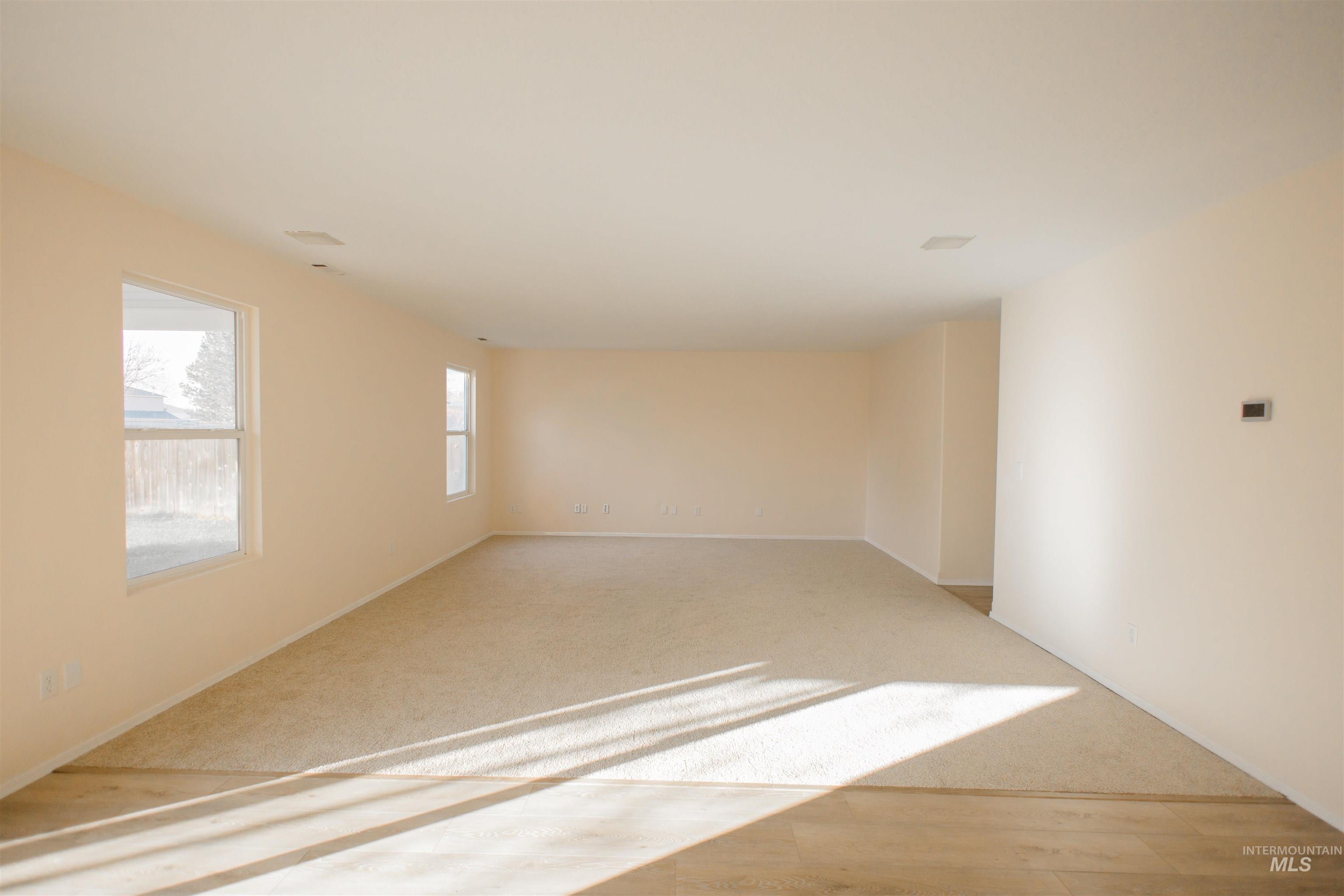 Empty room featuring light carpet