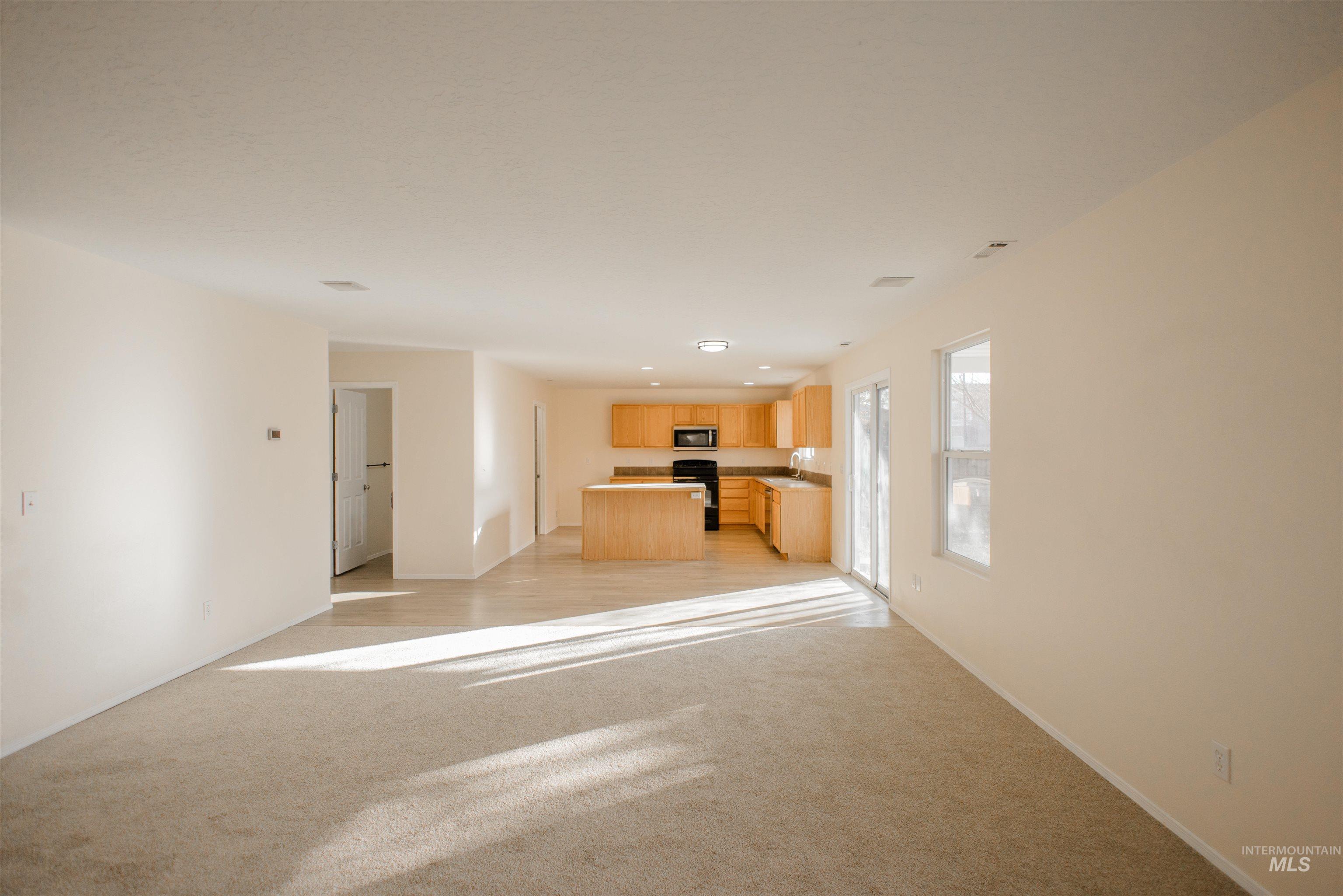 Unfurnished living room with light carpet and recessed lighting