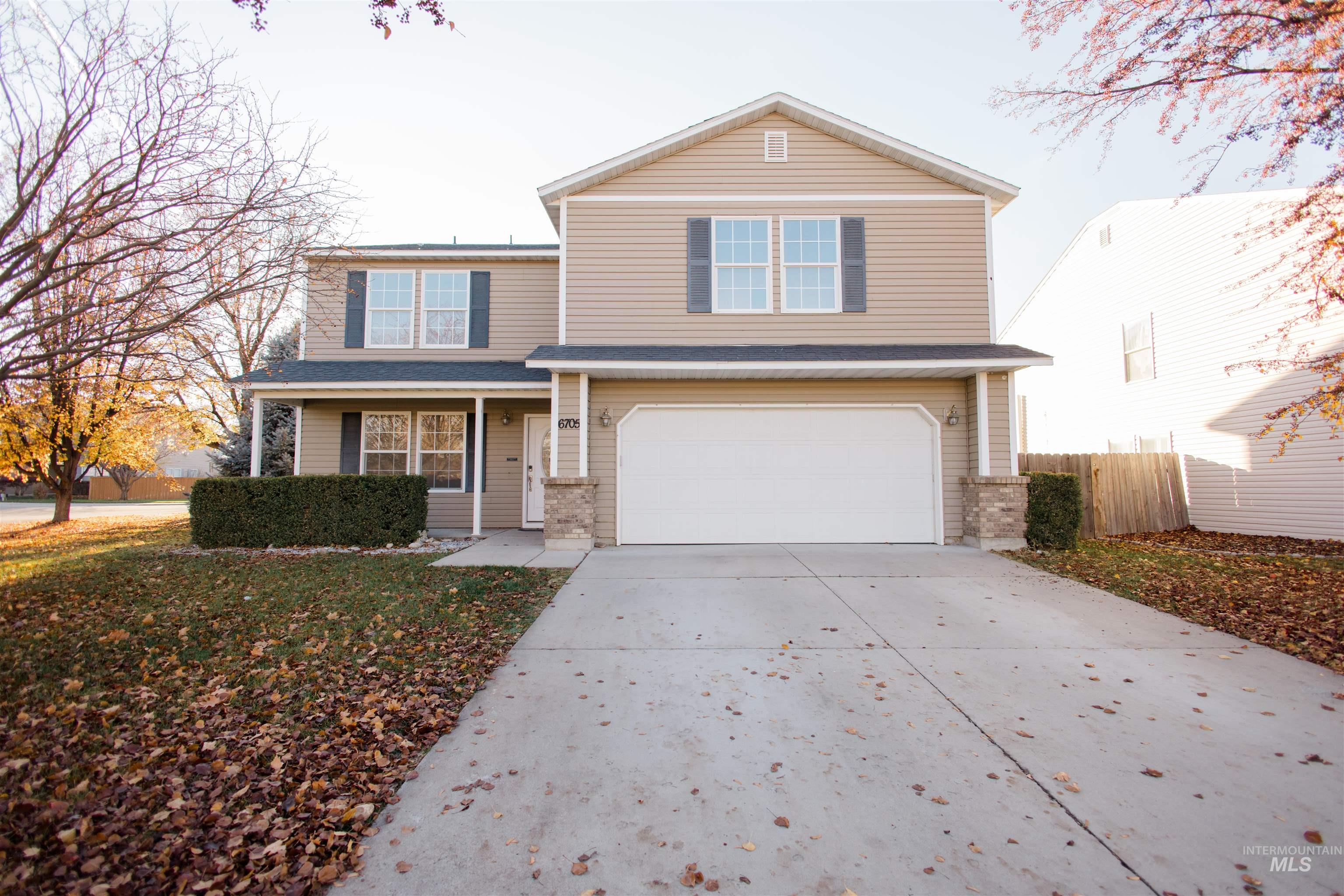 Traditional-style home with a porch, concrete driveway, a garage, and a shingled roof