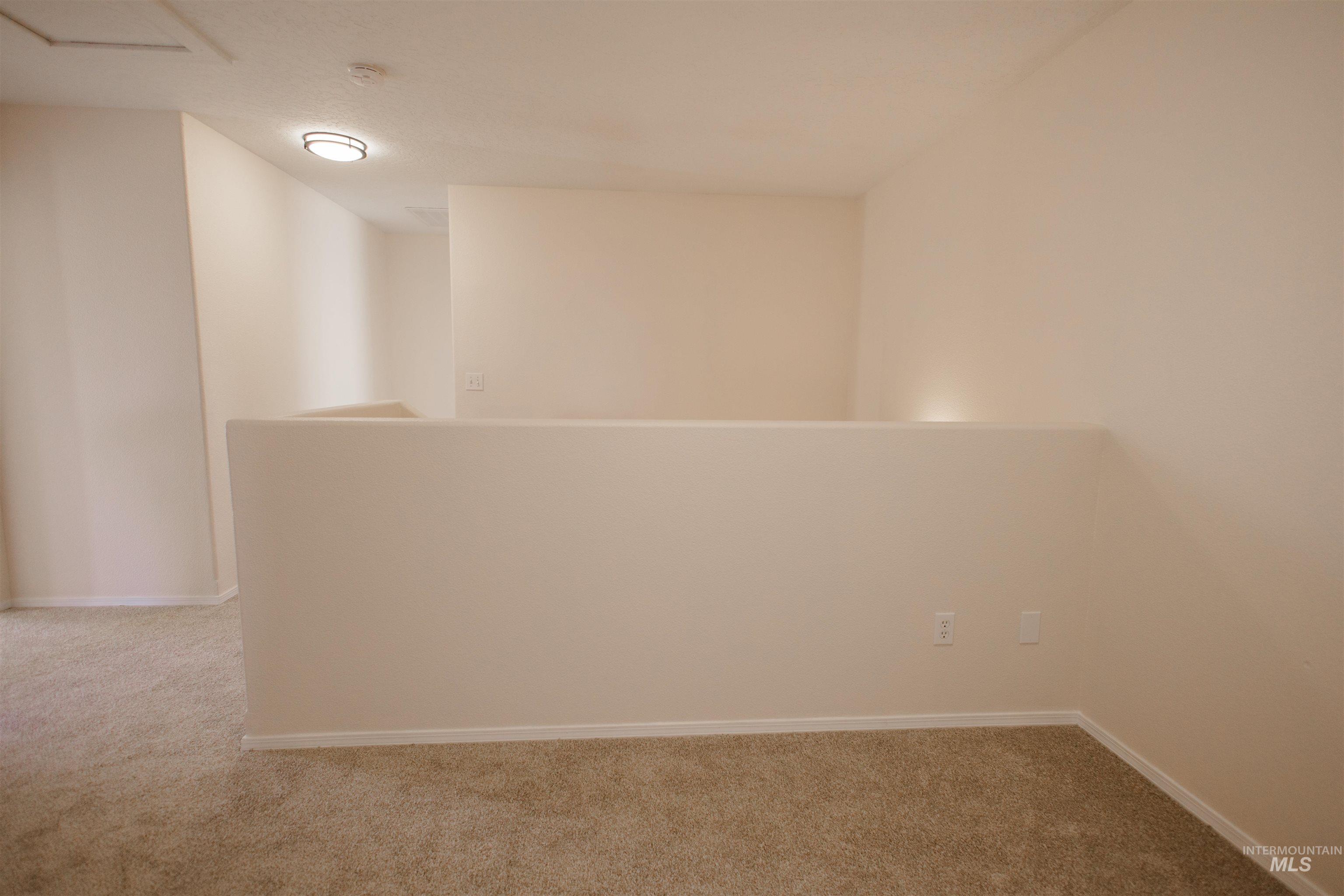 Unfurnished room featuring light colored carpet and baseboards
