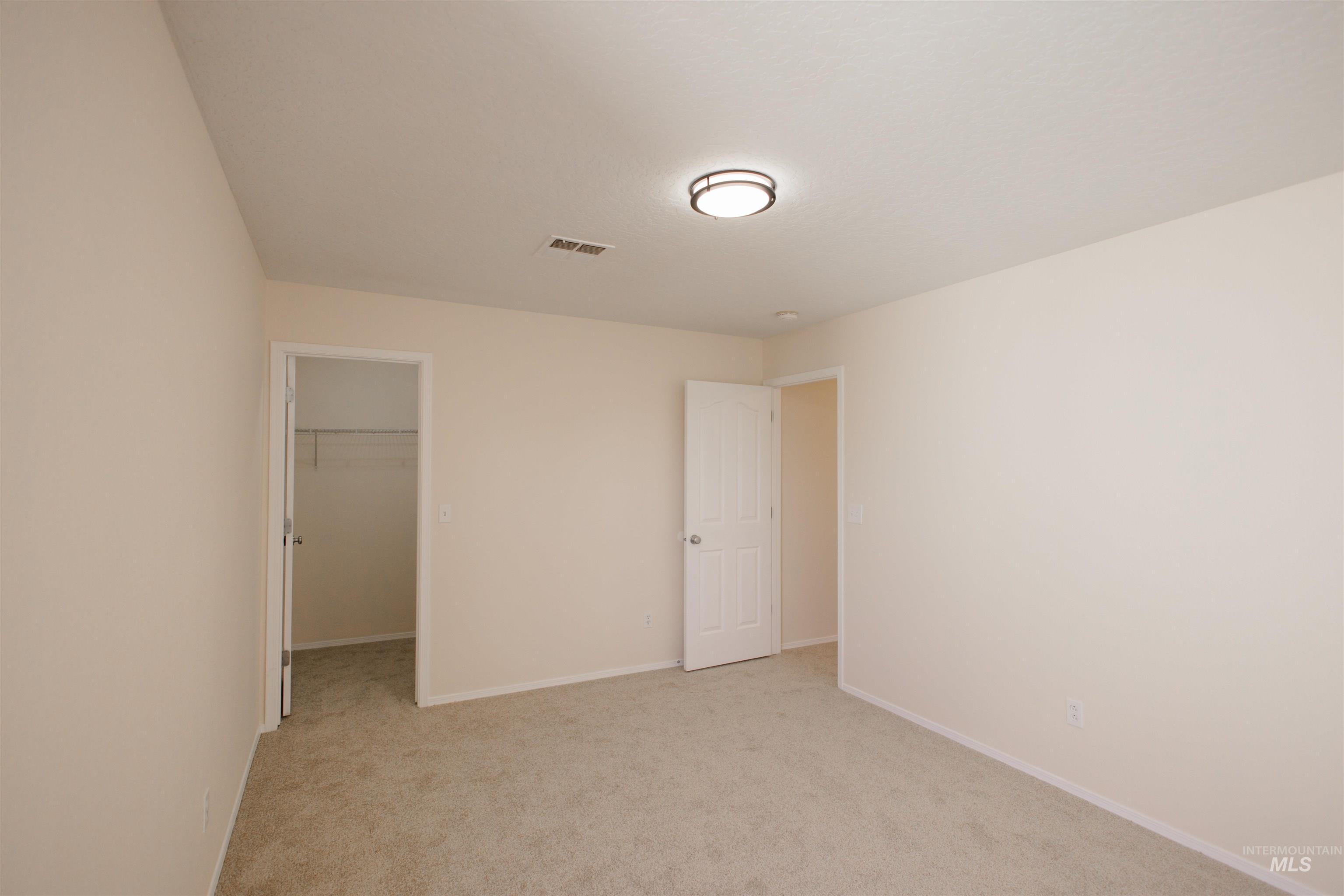 Unfurnished bedroom featuring a spacious closet and light colored carpet