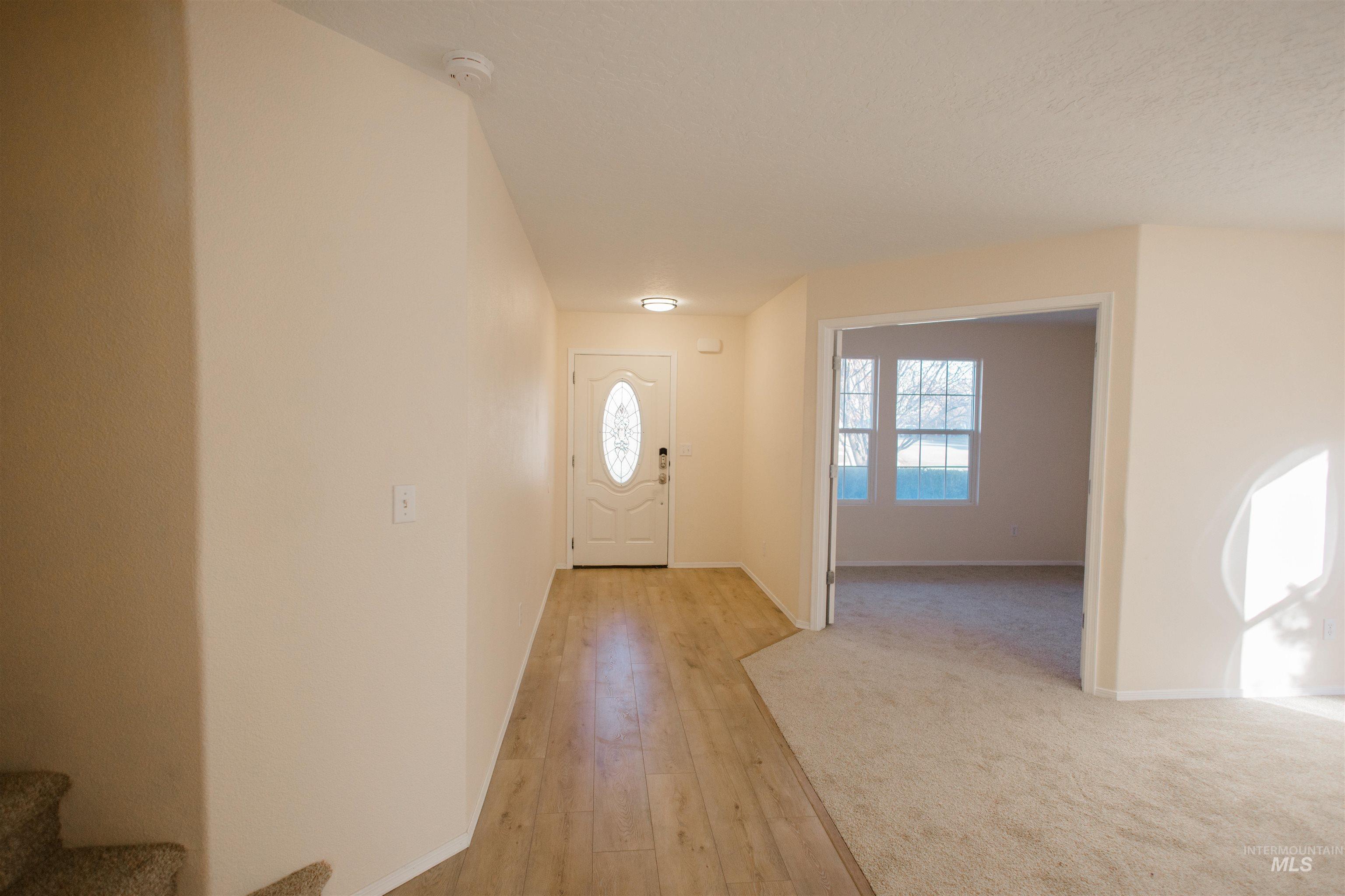 Entrance foyer with light wood-type flooring and stairway
