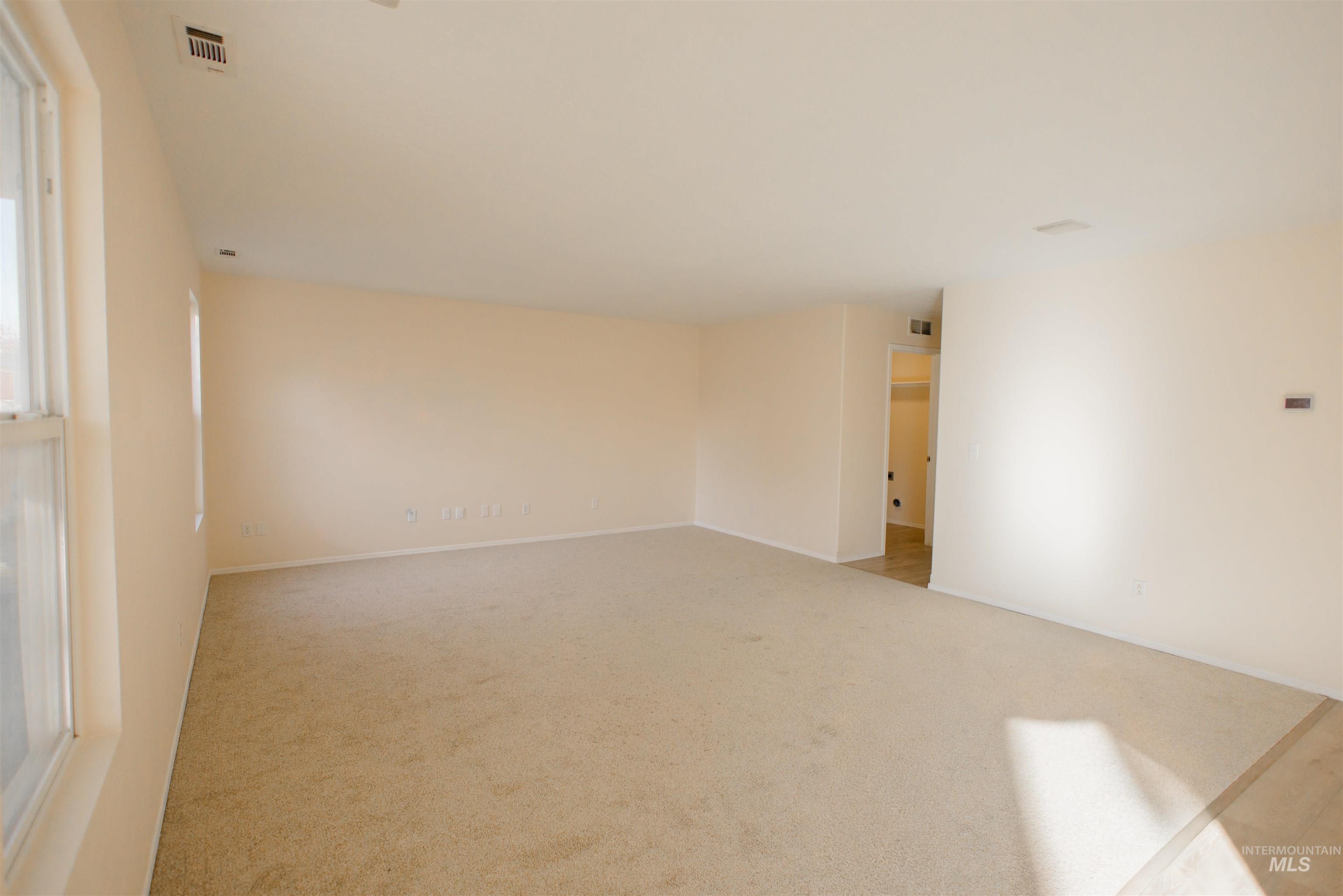 Empty room featuring light carpet