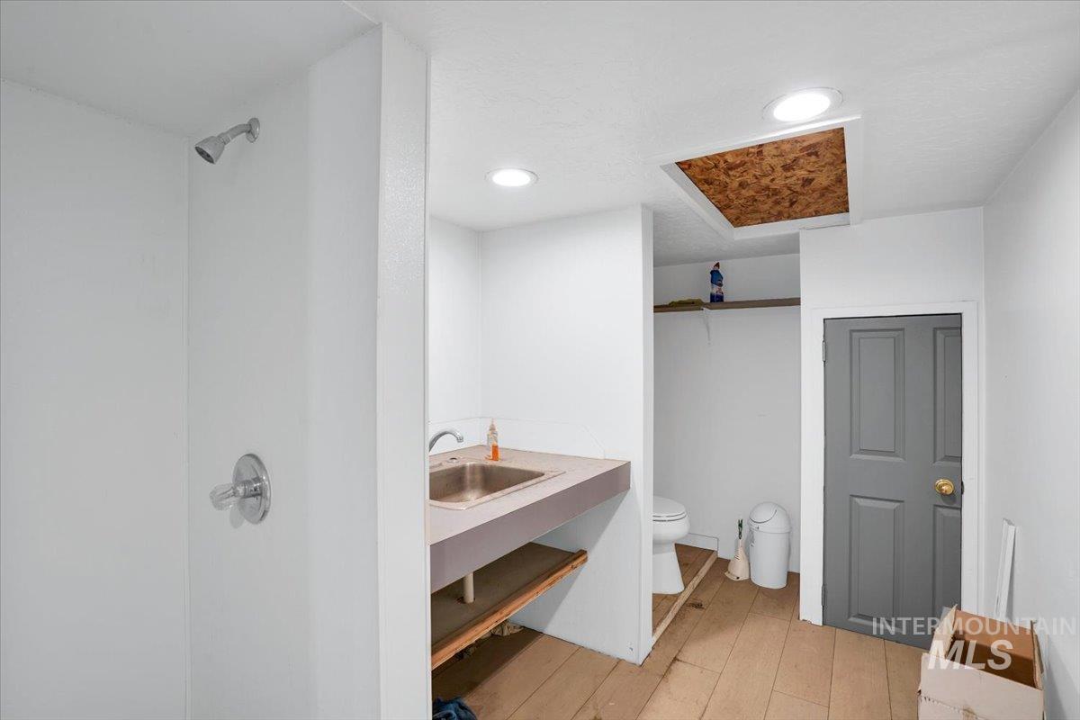Full bath featuring vanity, light wood finished floors, recessed lighting, and a shower