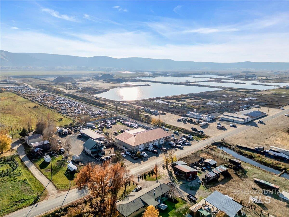 Aerial view of property and surrounding area with an industrial area and a water and mountain view