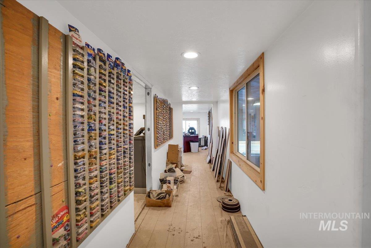Hallway with light wood-type flooring and recessed lighting