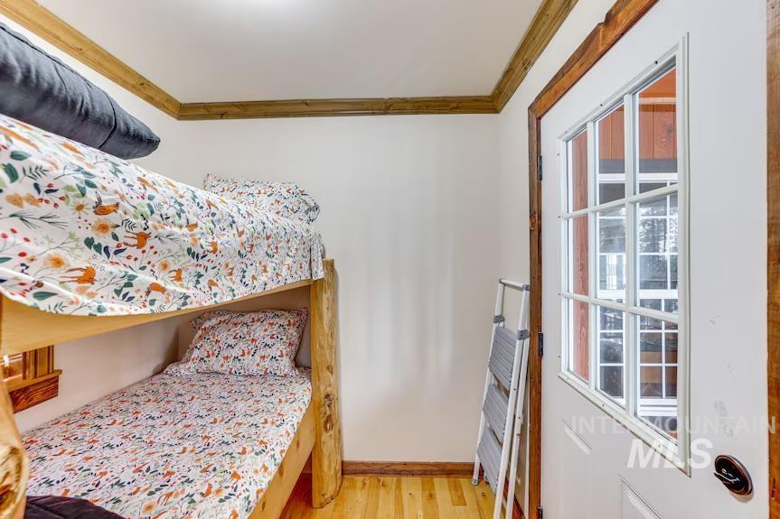 Bedroom featuring crown molding and light wood-style floors