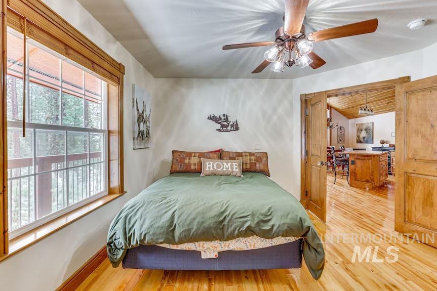 Bedroom featuring light wood-style flooring, a ceiling fan, and vaulted ceiling