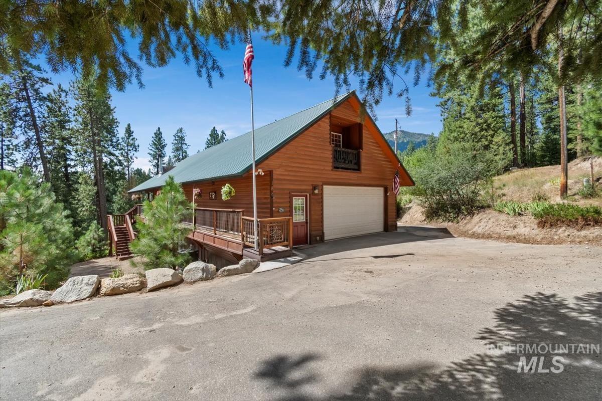 View of side of property with a deck, stairway, and a metal roof