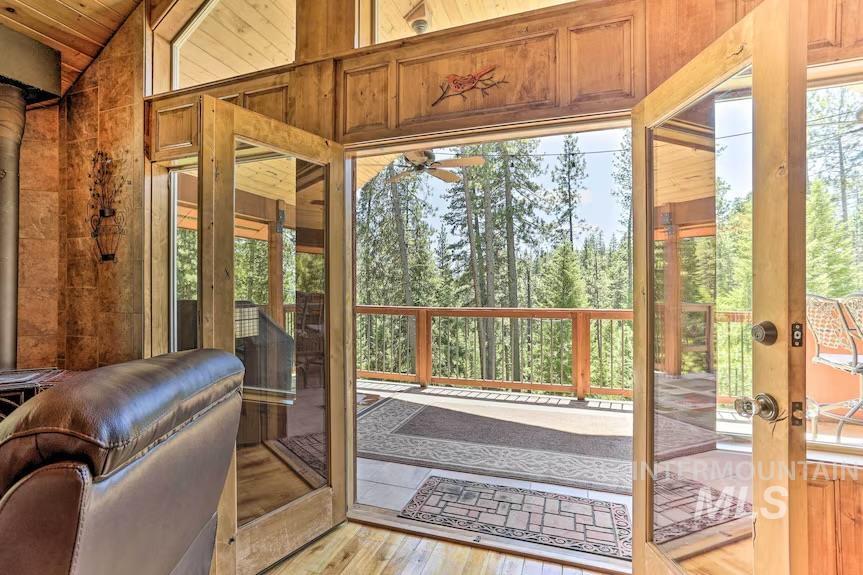 Doorway featuring light wood finished floors, lofted ceiling, a ceiling fan, and french doors