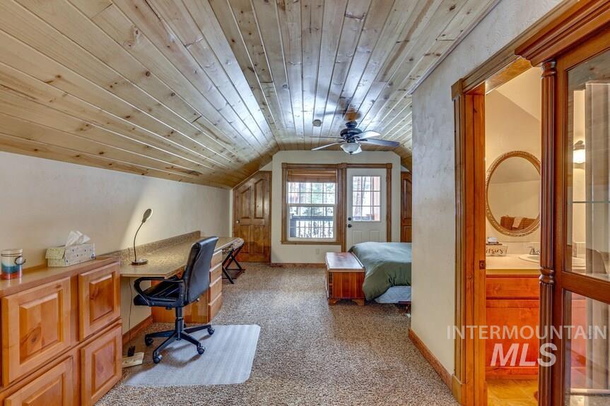 Home office with lofted ceiling, wooden ceiling, light colored carpet, and ceiling fan