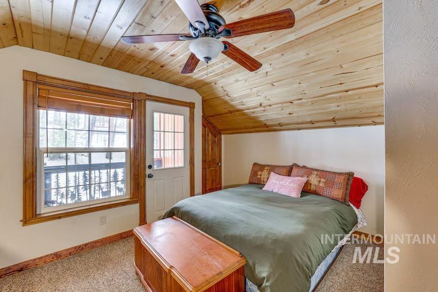 Carpeted bedroom with vaulted ceiling, wood ceiling, and ceiling fan