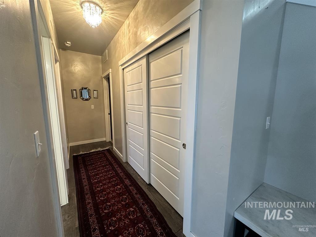 Hall with dark wood-style floors and baseboards