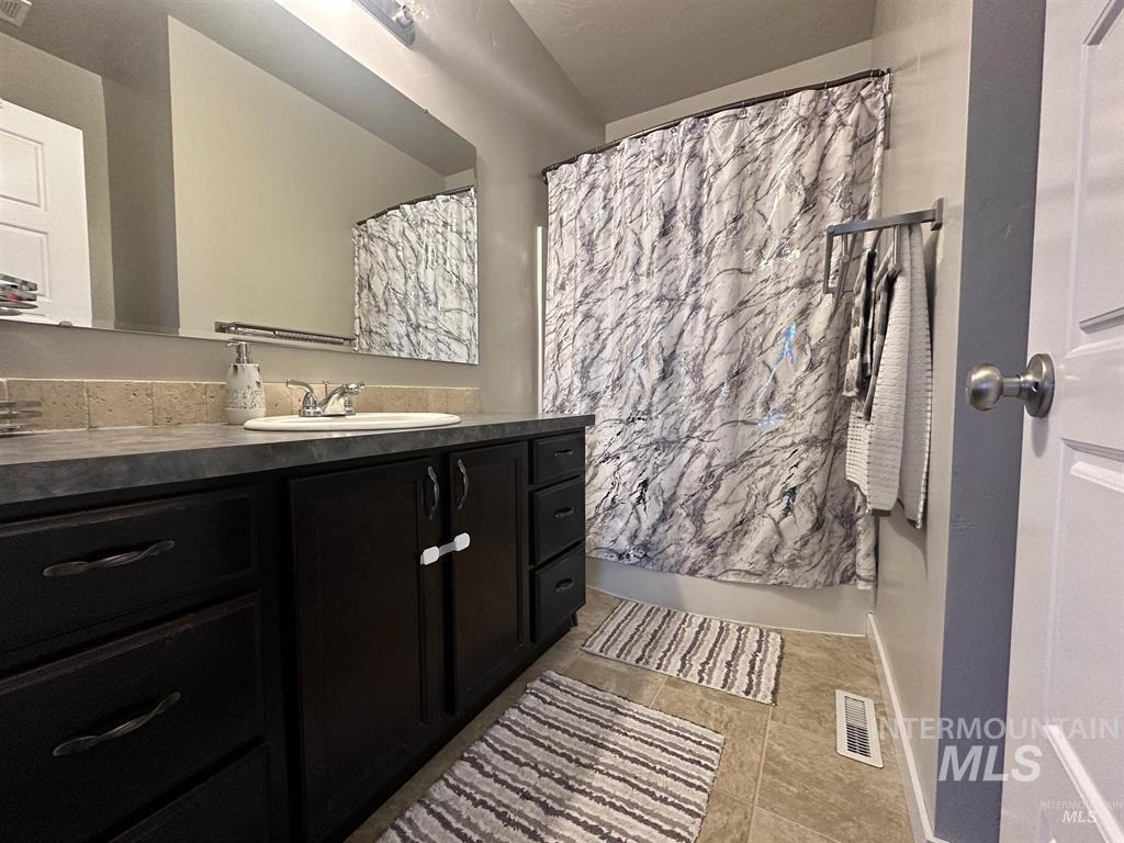 Full bathroom featuring vanity and light tile patterned floors