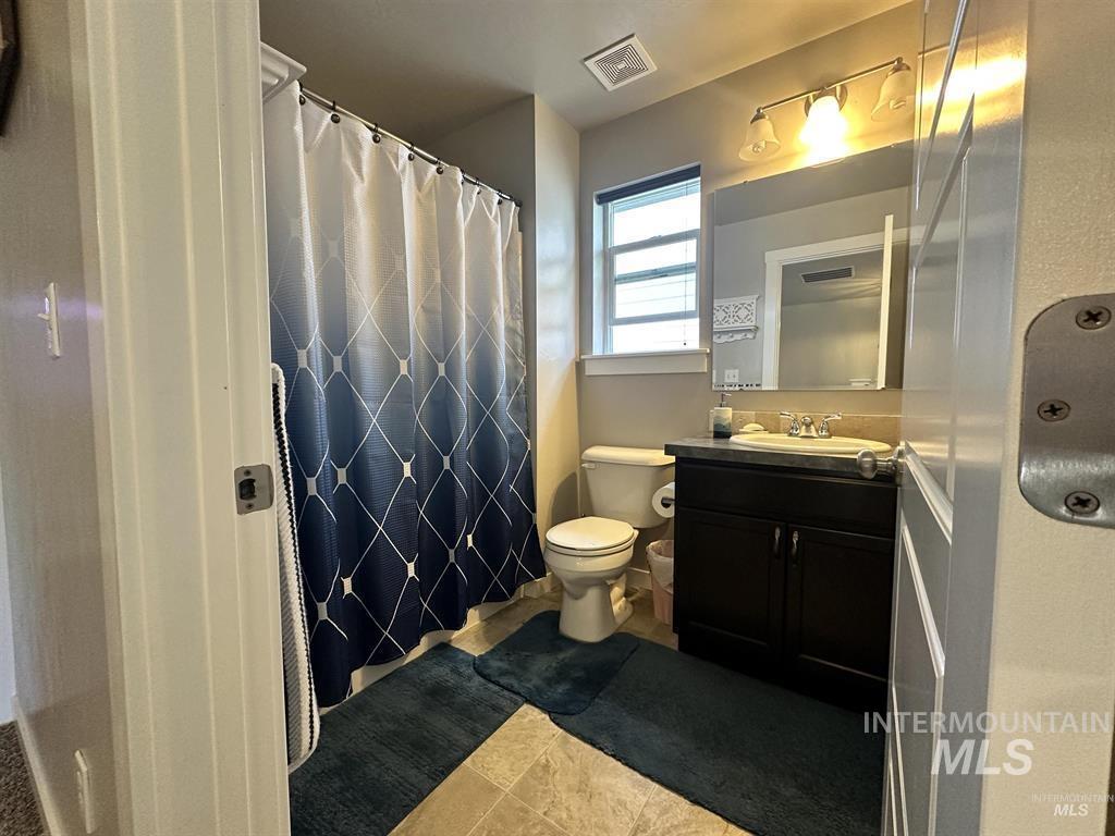 Bathroom featuring vanity, curtained shower, and light tile patterned floors
