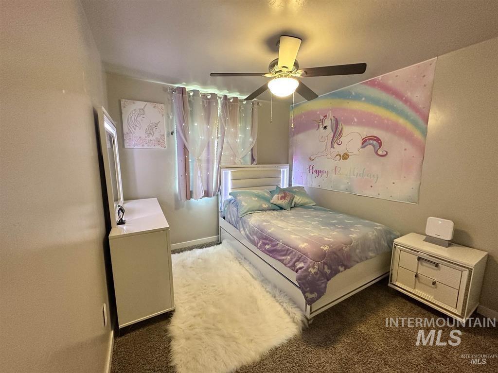 Bedroom featuring dark carpet and ceiling fan