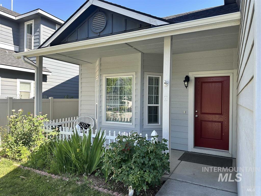 Doorway to property with a porch and a shingled roof