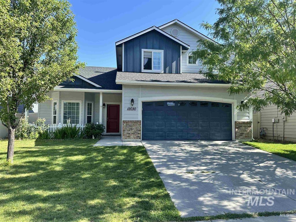 View of front of home with board and batten siding, a garage, concrete driveway, a front yard, and a porch