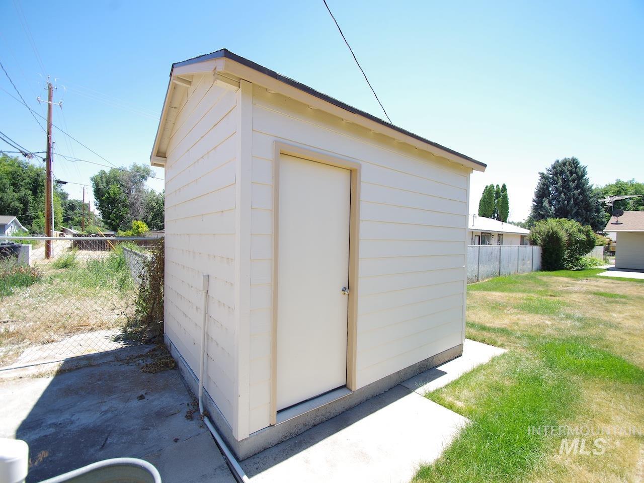 Detached utility shed with horizontal siding and a single entry door