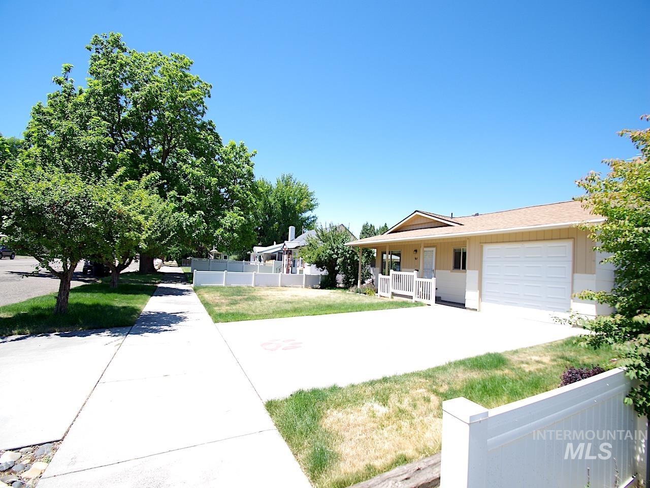 Single-story residence featuring a two-tone exterior, an attached garage, and a covered front porch with white railings