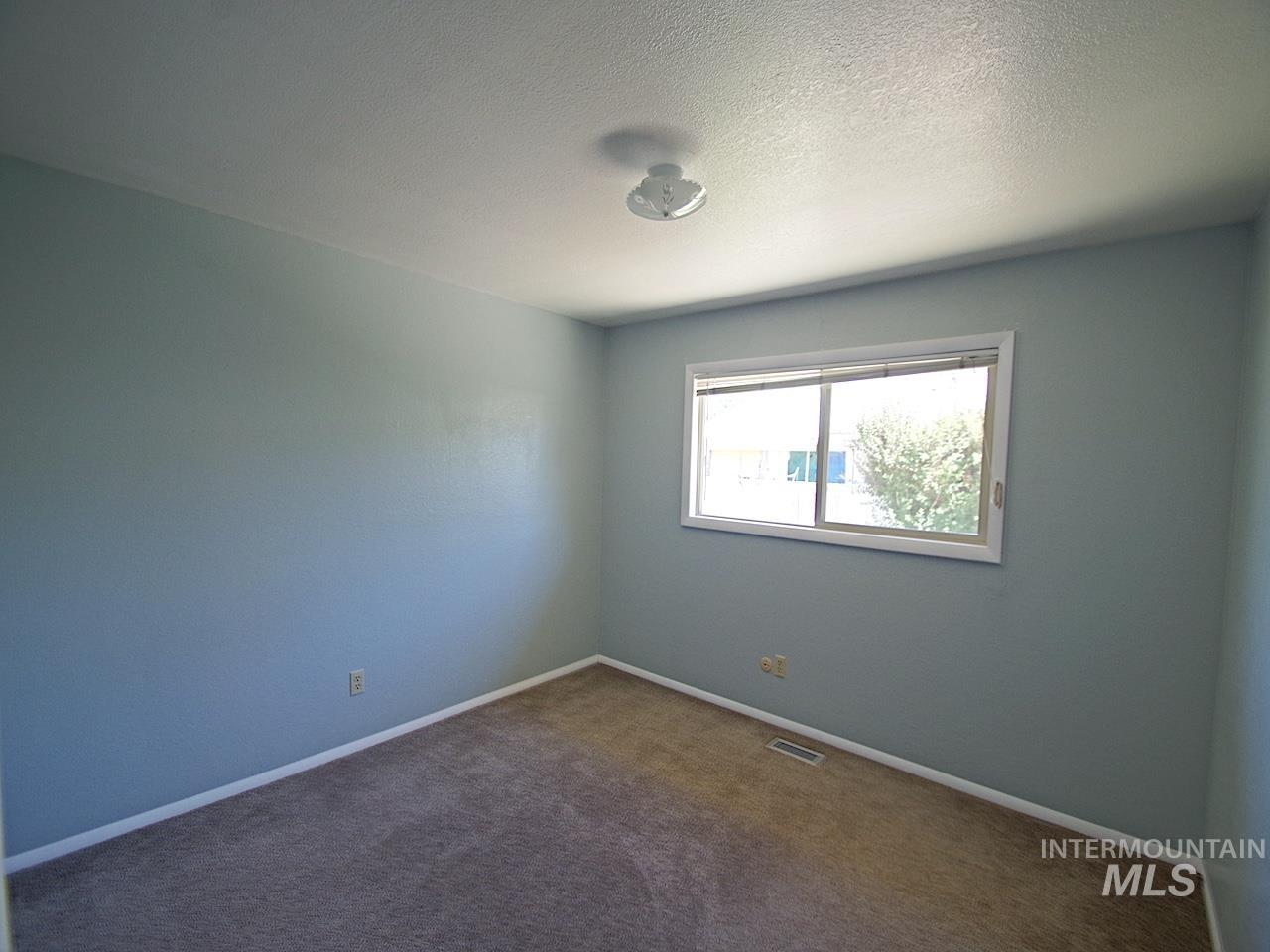 Carpeted room with light blue walls, white trim, and a white ceiling