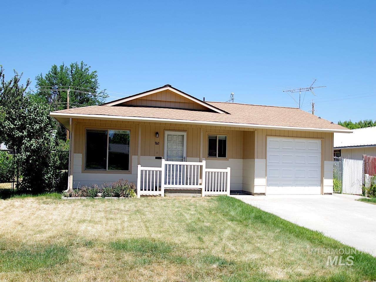 Single-story residence featuring a shingled roof, light-toned siding, and a single-car garage with a panel door