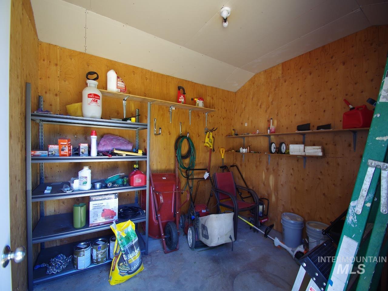 Utility shed with plywood walls and a concrete floor