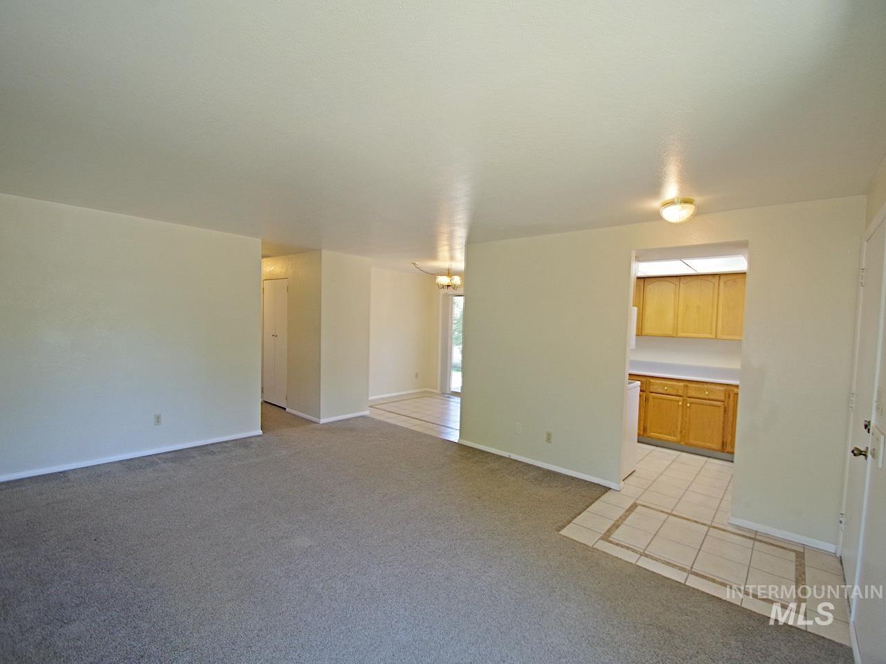 Spacious room featuring neutral carpeting, light-toned walls, and flush-mounted ceiling lighting