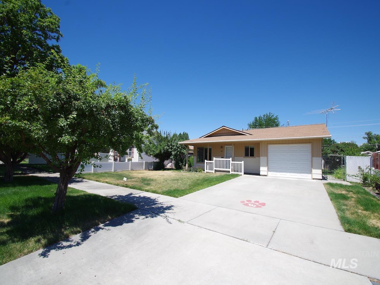 Ranch-style residence featuring a single-car garage, concrete driveway, and front porch with white railing